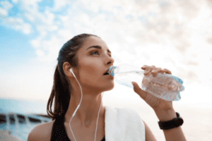 Jovem bebendo água potável em uma garrafa de plástico pet. Estudo revela uma solução simples e eficaz para remover nano ou microplásticos da água potável.