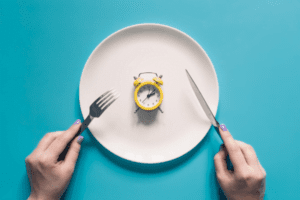 Jejum intermitente: prato vazio e relógio representando o período de jejum e alimentação.